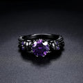 Anillo vintage redondo negro con una piedra preciosa morada
