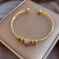 Pulsera ajustable con colgantes dorados