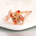 Anillo con piedra preciosa naranja tallada en forma de pirámide en oro rosa