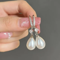 Pendientes brillantes con perlas colgantes